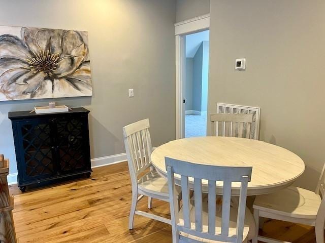 dining area featuring light wood-style flooring, visible vents, and baseboards