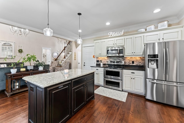 kitchen featuring tasteful backsplash, dark wood finished floors, ornamental molding, hanging light fixtures, and stainless steel appliances