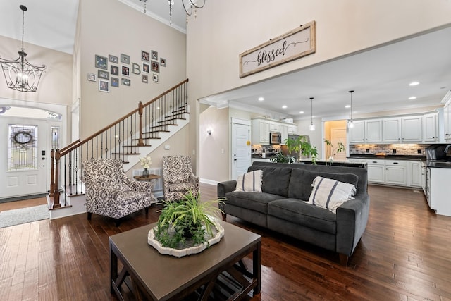 living area featuring a chandelier, recessed lighting, stairway, dark wood-style floors, and crown molding