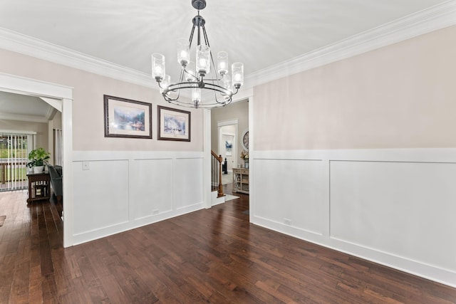 unfurnished dining area featuring stairway, a decorative wall, hardwood / wood-style floors, and ornamental molding