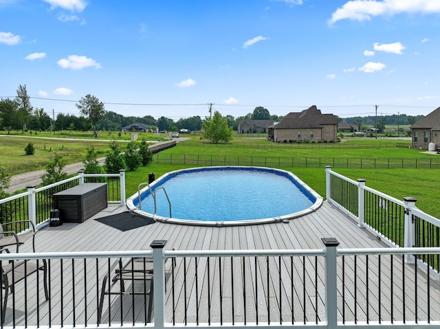 view of swimming pool with a wooden deck, fence, a fenced in pool, and a yard