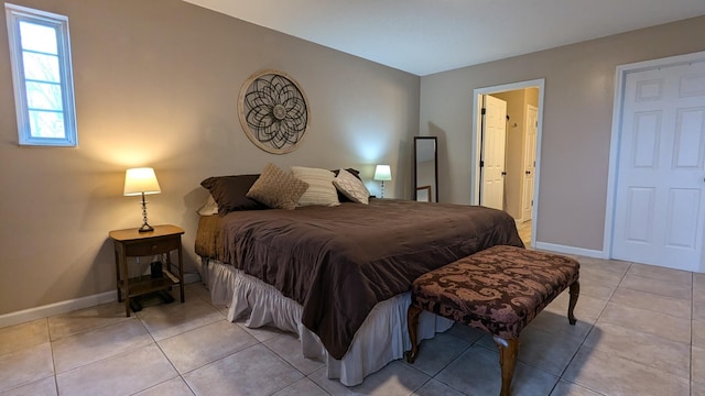 bedroom featuring tile patterned flooring, connected bathroom, and baseboards