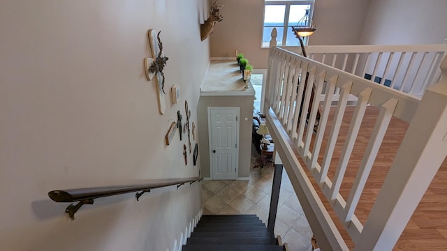 staircase with a high ceiling and tile patterned floors