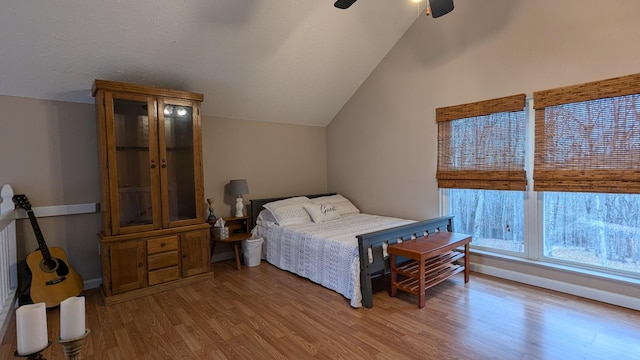 bedroom featuring lofted ceiling, ceiling fan, light wood-style flooring, and baseboards