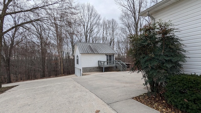 view of home's exterior with a garage, metal roof, and concrete driveway