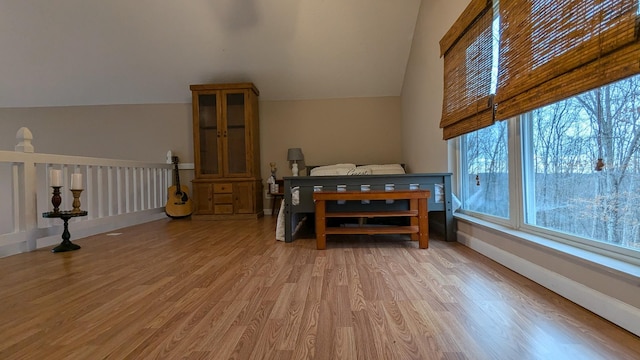 dining area with lofted ceiling, baseboards, and light wood-style floors