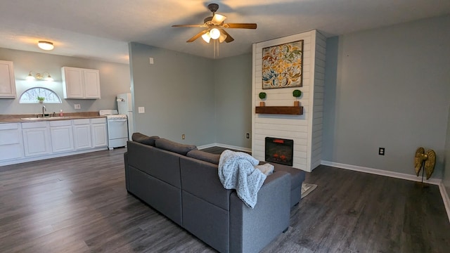 living area featuring ceiling fan, dark wood-style flooring, a fireplace, and baseboards