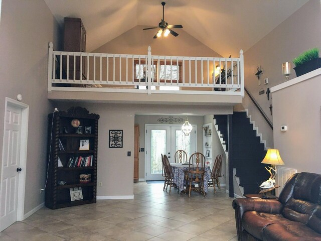 living room with ceiling fan, tile patterned flooring, stairs, french doors, and high vaulted ceiling