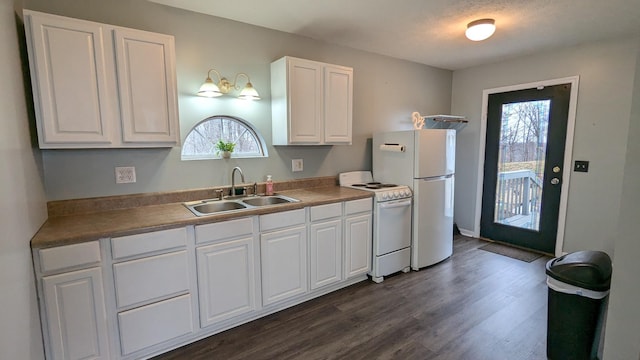 kitchen with white appliances, plenty of natural light, white cabinetry, and a sink