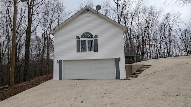 view of side of property with stairs and a detached garage