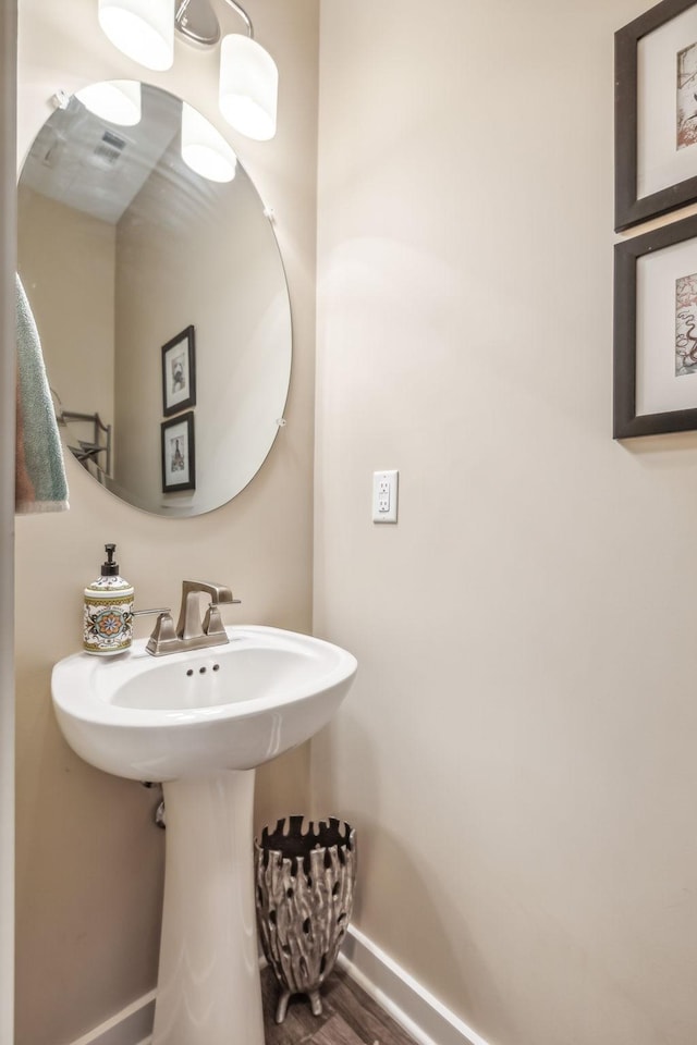 bathroom with baseboards and wood finished floors