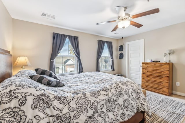 carpeted bedroom featuring ceiling fan, visible vents, and baseboards