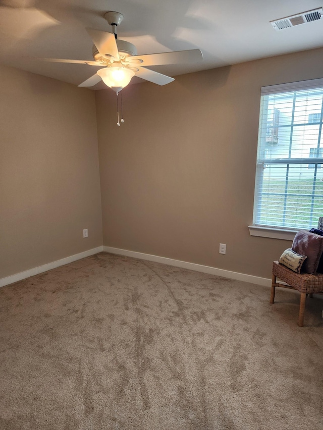 empty room featuring a ceiling fan, baseboards, visible vents, and carpet flooring