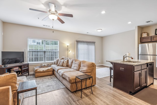 living room featuring recessed lighting, visible vents, a ceiling fan, light wood-type flooring, and baseboards