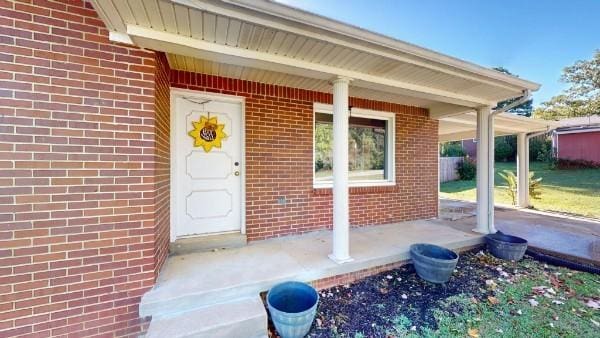 view of exterior entry with brick siding