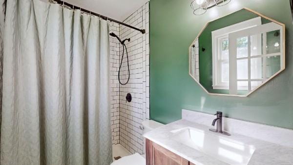 full bathroom with a stall shower, vanity, and toilet