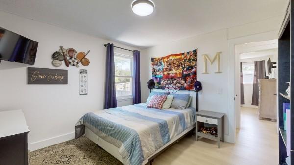 bedroom featuring wood finished floors and baseboards