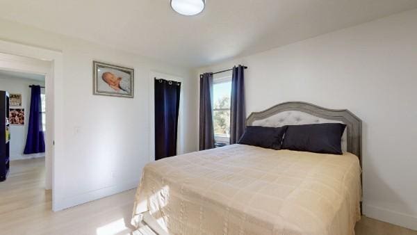 bedroom featuring wood finished floors and baseboards