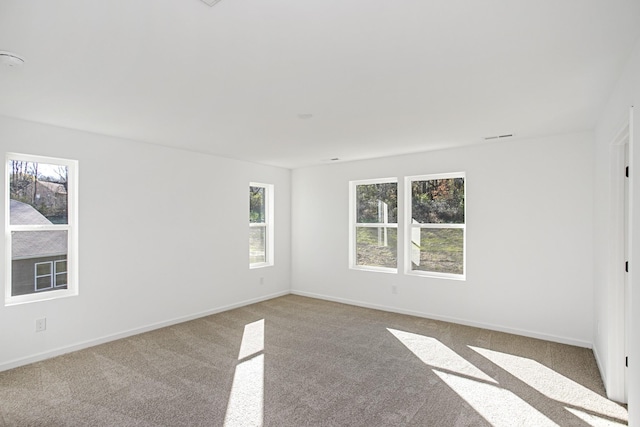 empty room with visible vents, baseboards, and carpet flooring