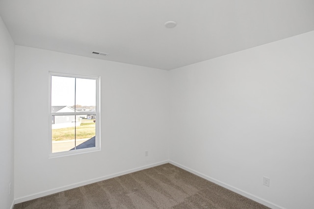 carpeted empty room featuring visible vents and baseboards