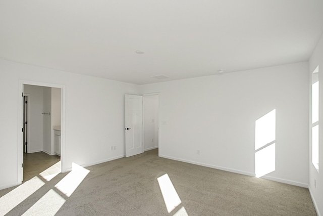 unfurnished bedroom featuring light carpet and baseboards