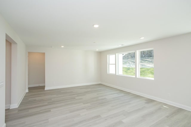 unfurnished room featuring recessed lighting, light wood finished floors, and baseboards