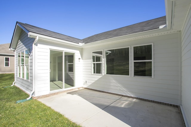 exterior space with a patio area, a yard, and roof with shingles