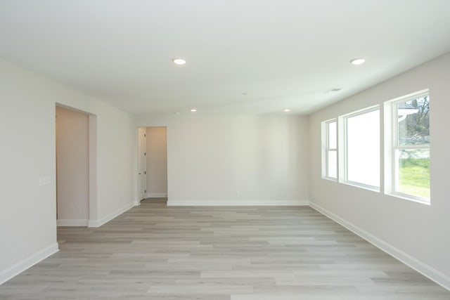 empty room with light wood-style flooring, baseboards, and recessed lighting