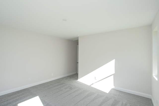 unfurnished room with carpet floors and baseboards