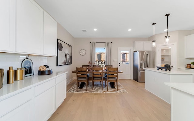 dining area with light wood finished floors, visible vents, and recessed lighting