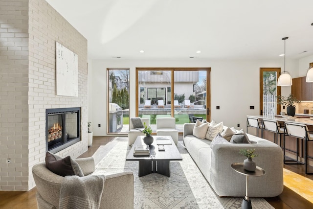 living room featuring a fireplace, wood finished floors, and recessed lighting