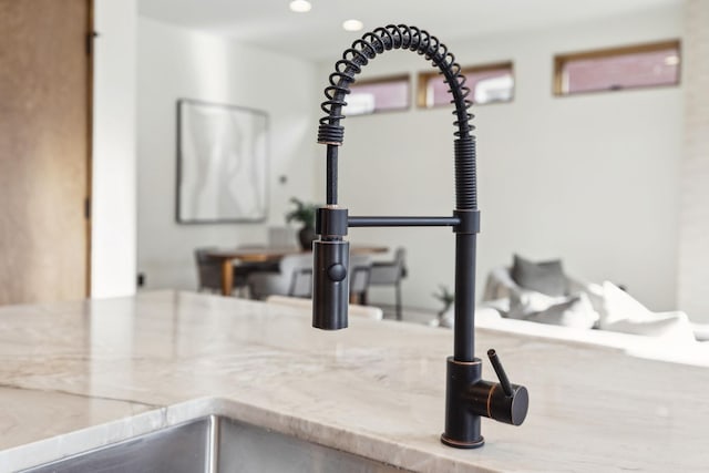 room details with stone counters, a sink, and recessed lighting