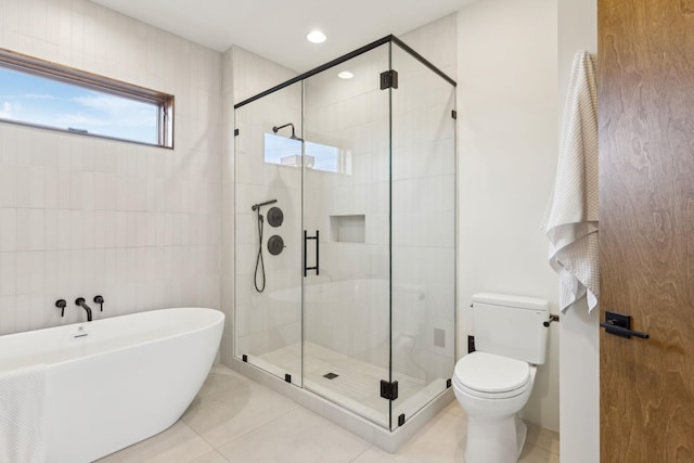 bathroom featuring a stall shower, a soaking tub, toilet, and tile patterned floors