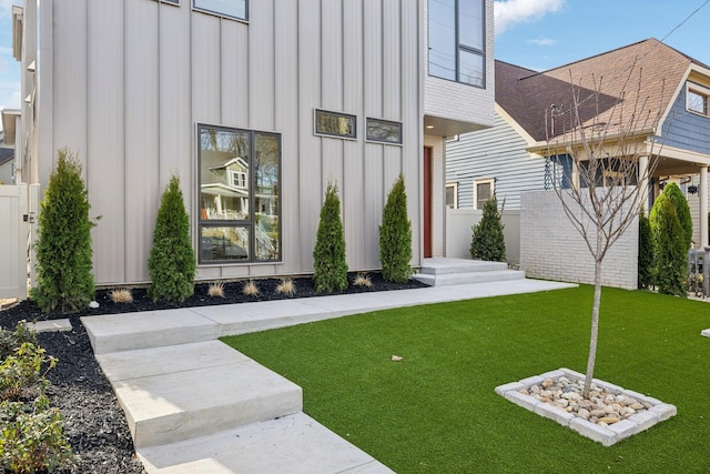 exterior space with a yard, board and batten siding, and fence