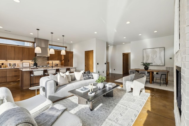 living room with concrete flooring, recessed lighting, a large fireplace, and visible vents