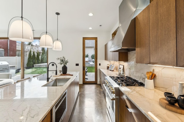 kitchen with stainless steel appliances, modern cabinets, a sink, and brown cabinets