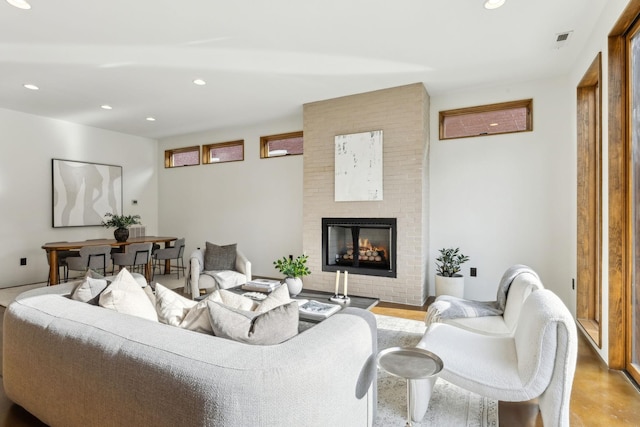 living room featuring recessed lighting, a brick fireplace, and visible vents