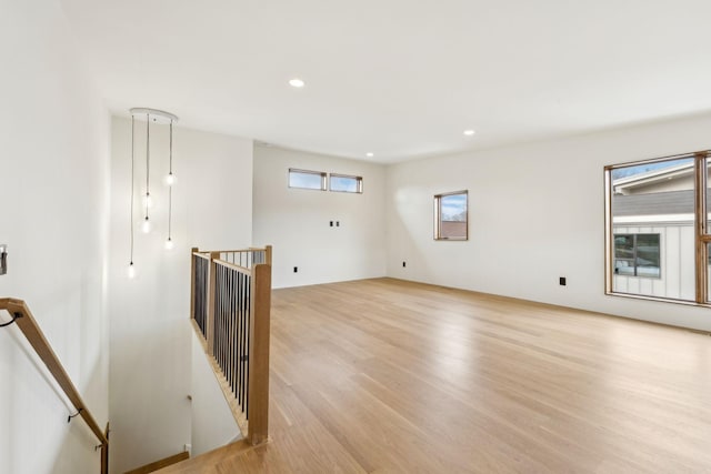 empty room with light wood-style floors and recessed lighting