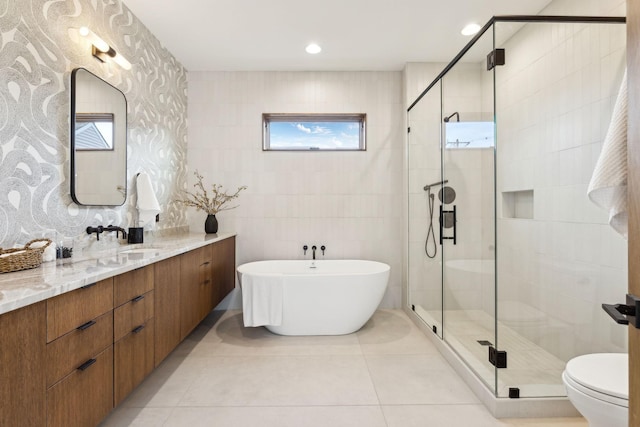 bathroom featuring tile walls, a soaking tub, a shower stall, vanity, and tile patterned flooring