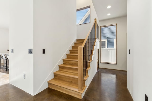 staircase featuring concrete flooring and recessed lighting