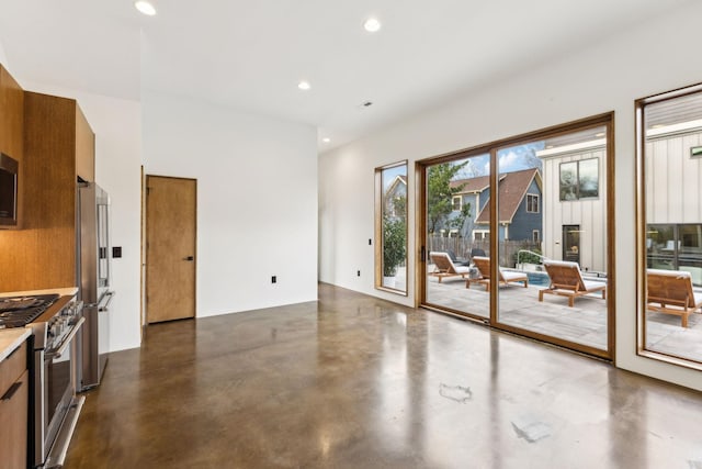 interior space with brown cabinets, stainless steel appliances, concrete flooring, and recessed lighting