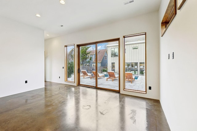 doorway to outside with concrete flooring, recessed lighting, and visible vents