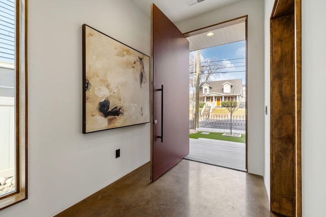 foyer entrance featuring plenty of natural light and concrete flooring