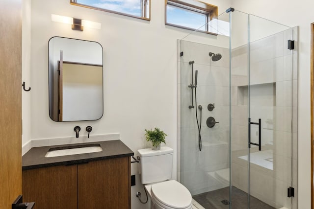 full bathroom with a stall shower, vanity, and toilet