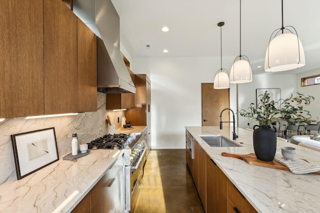 kitchen with brown cabinetry, stainless steel range, wall chimney range hood, and a sink