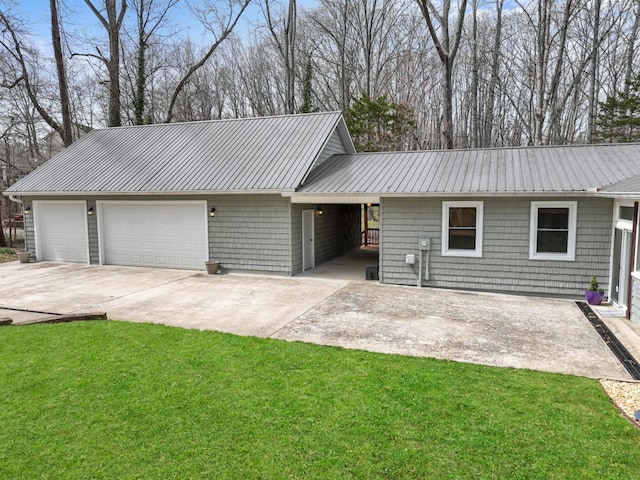 view of front of property featuring a garage, concrete driveway, a front lawn, and metal roof
