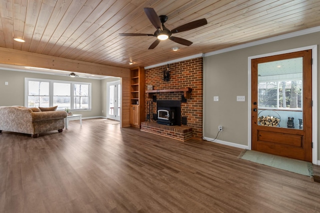 living room with wood ceiling, a wood stove, baseboards, and ceiling fan