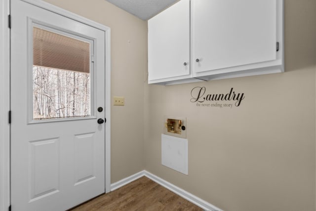 clothes washing area with wood finished floors, baseboards, washer hookup, and cabinet space