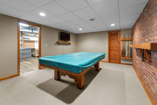 rec room featuring a paneled ceiling, baseboards, visible vents, carpet, and brick wall