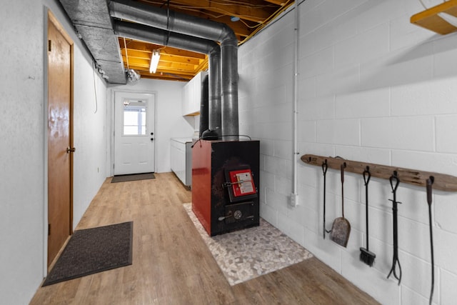 below grade area featuring concrete block wall, light wood-style floors, and washer / clothes dryer